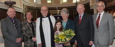 L to R: Peter Pratt (Rector’s Warden), Maureen Campbell (People’s Warden), Rev Canon William Bell, Norma Bell, David Kingan (Select Vestry) and Dan McCormick (Men’s Fellowship).  Included is Caroline Simpson who presented flowers to Mrs Norma Bell.